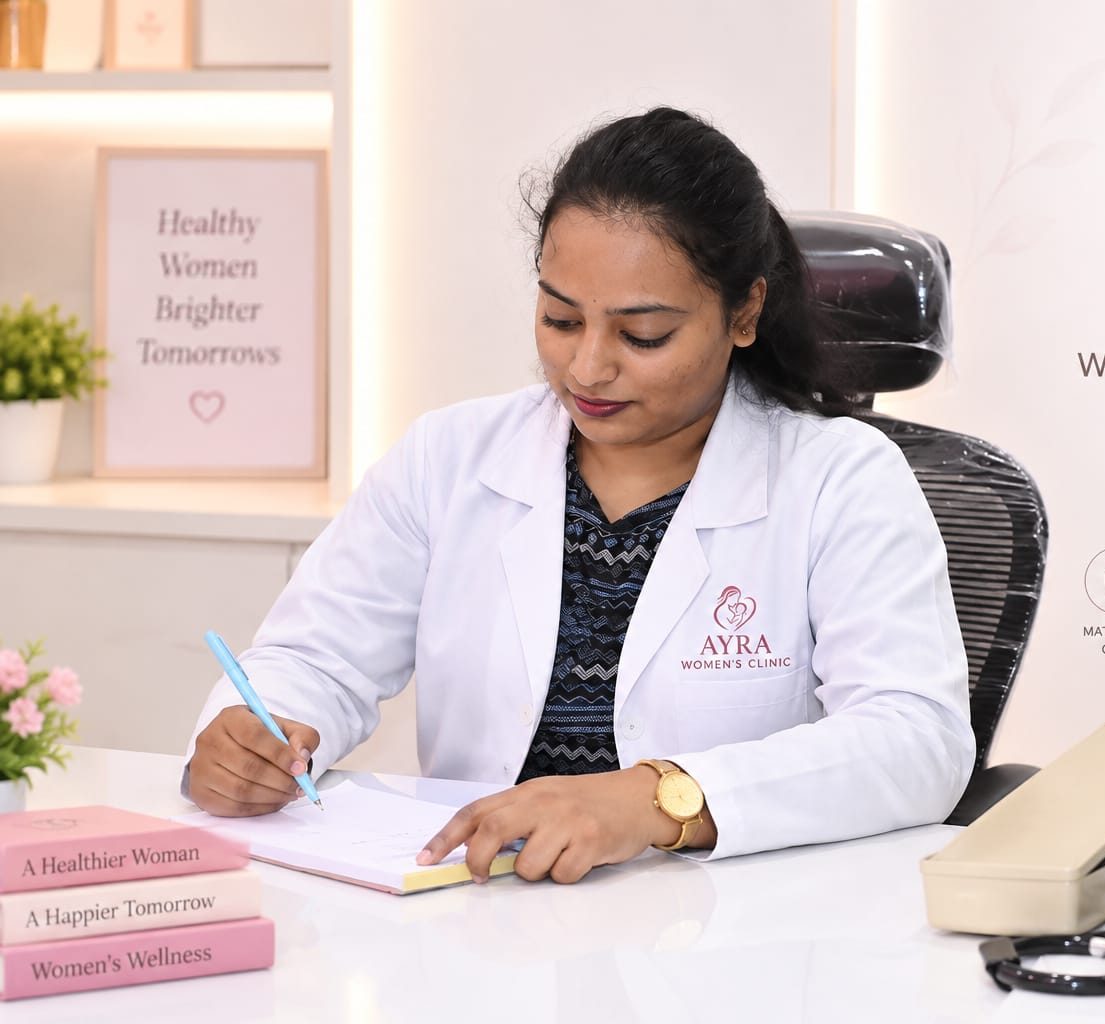 Dr. Annu Murali writing notes at her desk in Ayra Women's Clinic